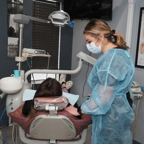 Dental professional assisting a patient during a dental examination at Dental Art Clinic in Cambridge