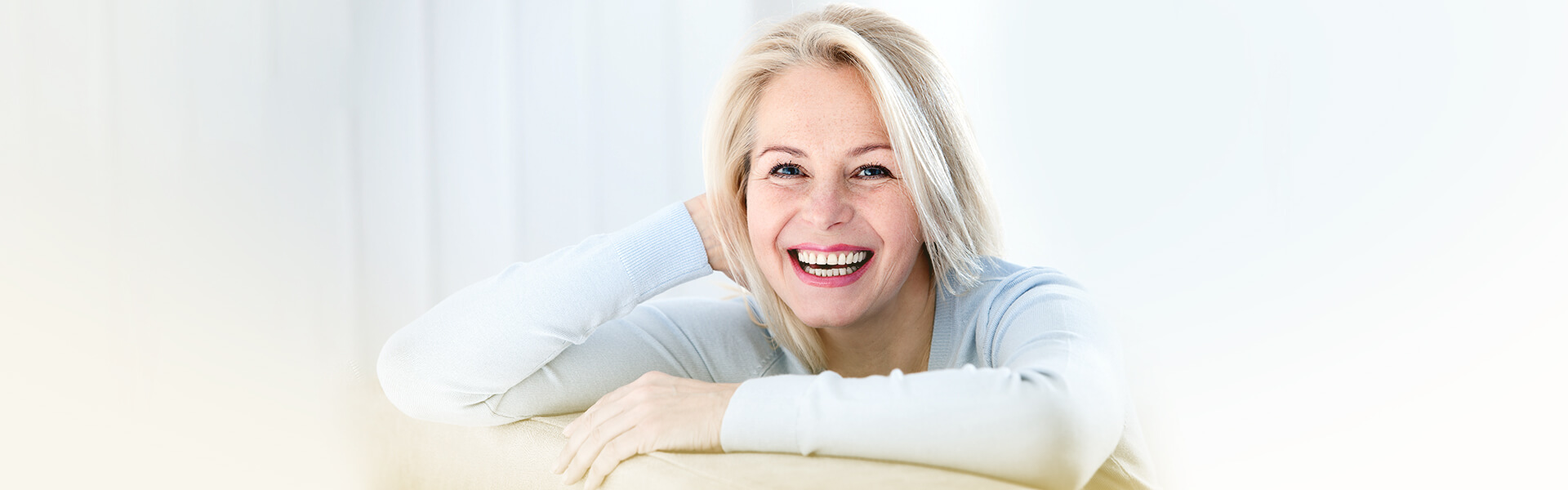 A woman resting on her arms and smiling broadly