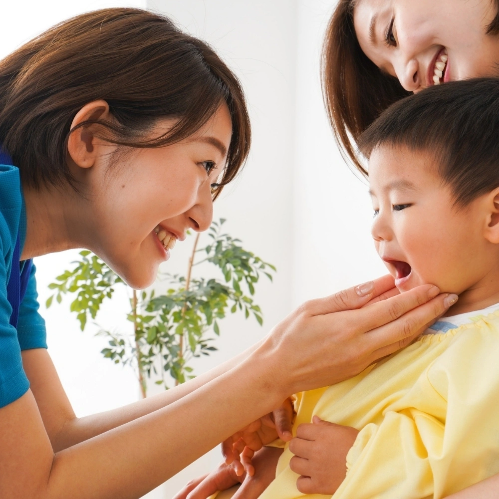 Dentist gently examining a young child’s mouth during a pediatric check-up at Dental Art Clinic
