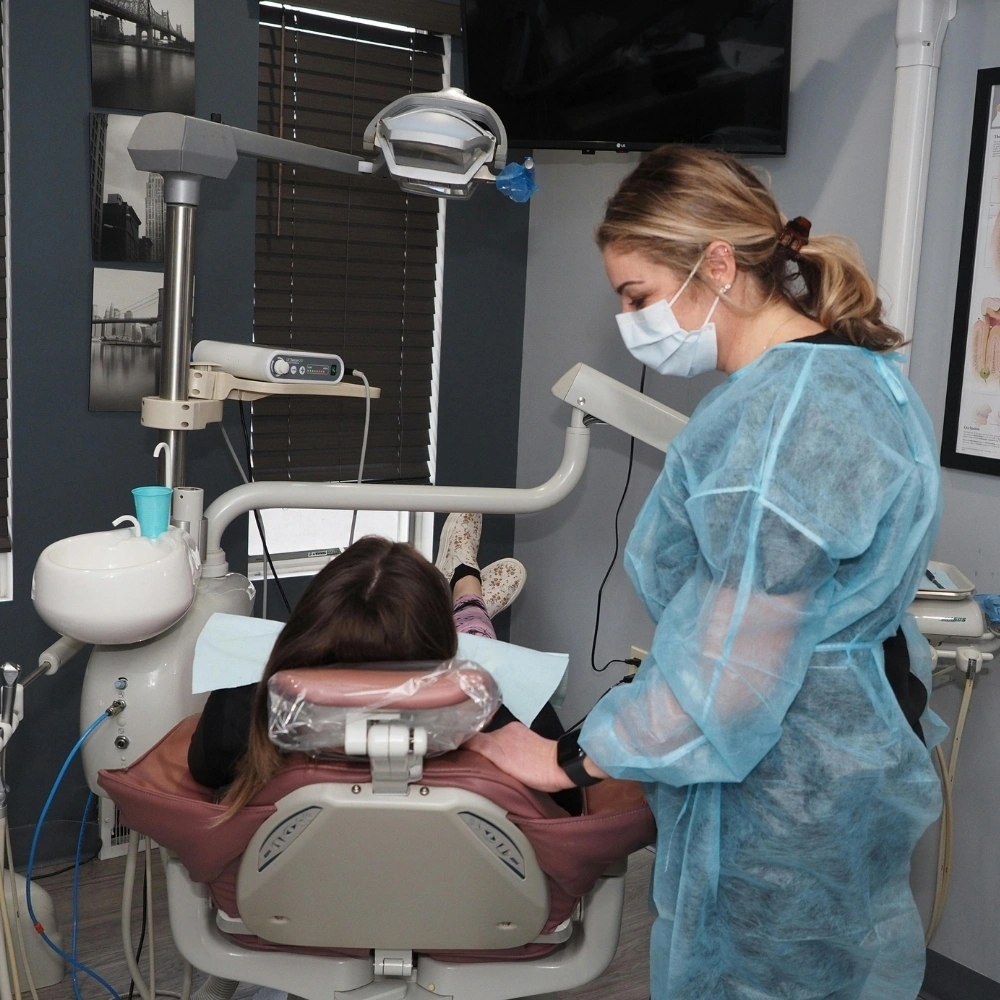 Dental professional assisting a patient during a dental examination at Dental Art Clinic in Cambridge