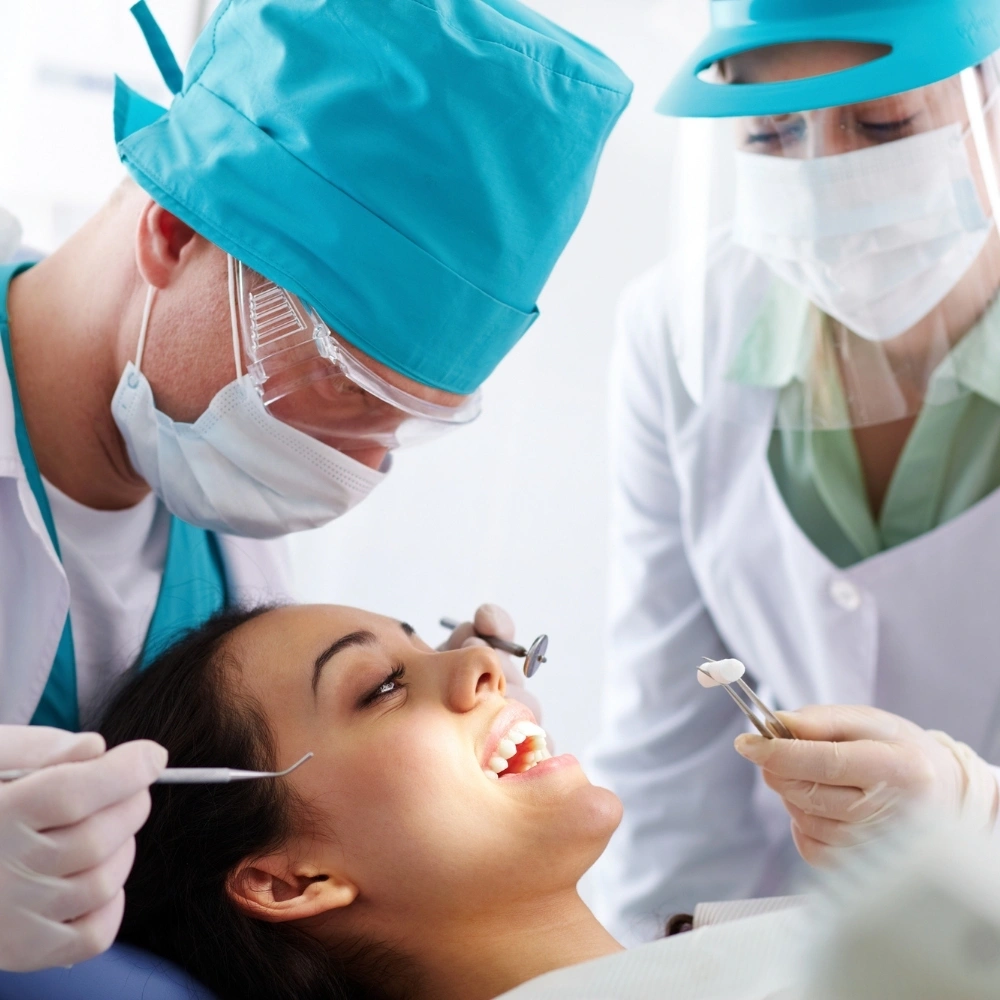 Dentists performing a dental crown placement procedure for a patient at Dental Art Clinic in Cambridge.