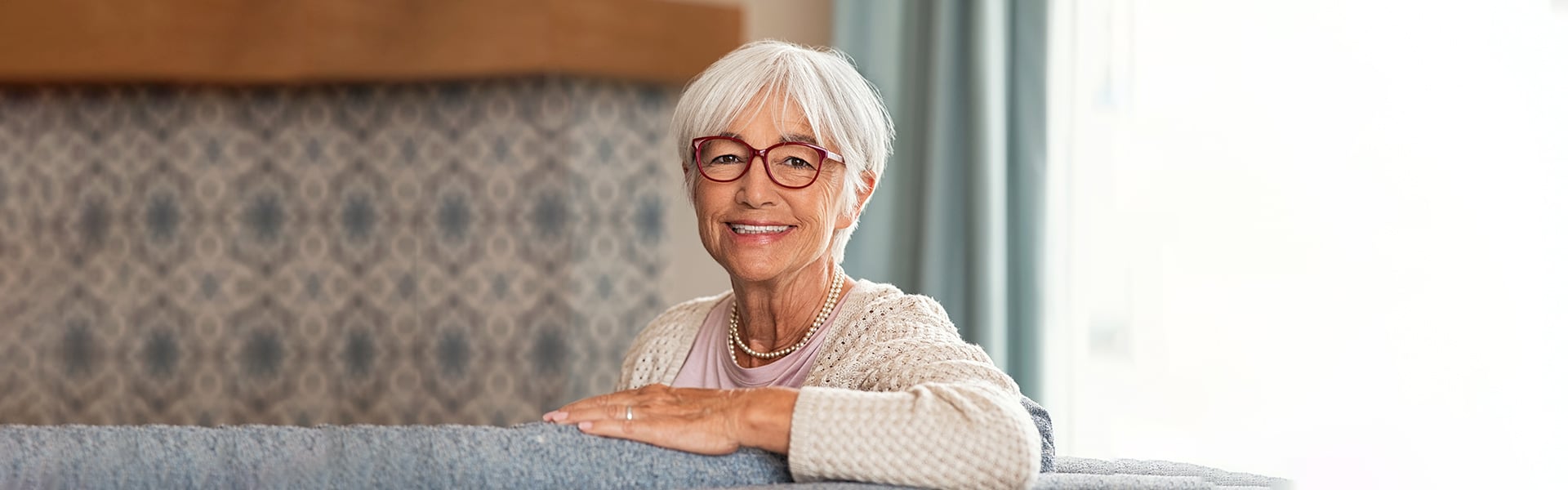 Senior woman smiling confidently with dental implants in Cambridge