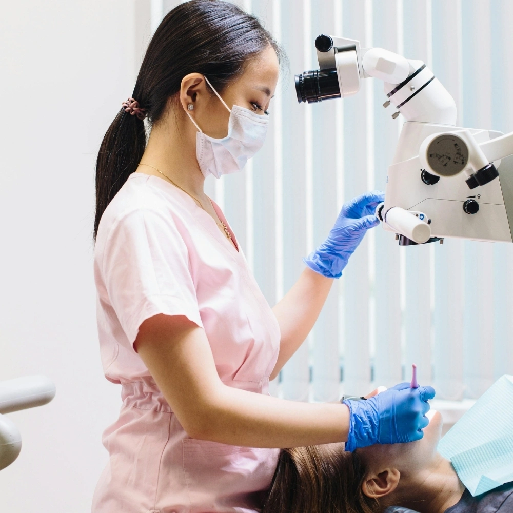Dentist performing microscope-assisted root canal treatment at Dental Art Clinic in Cambridge