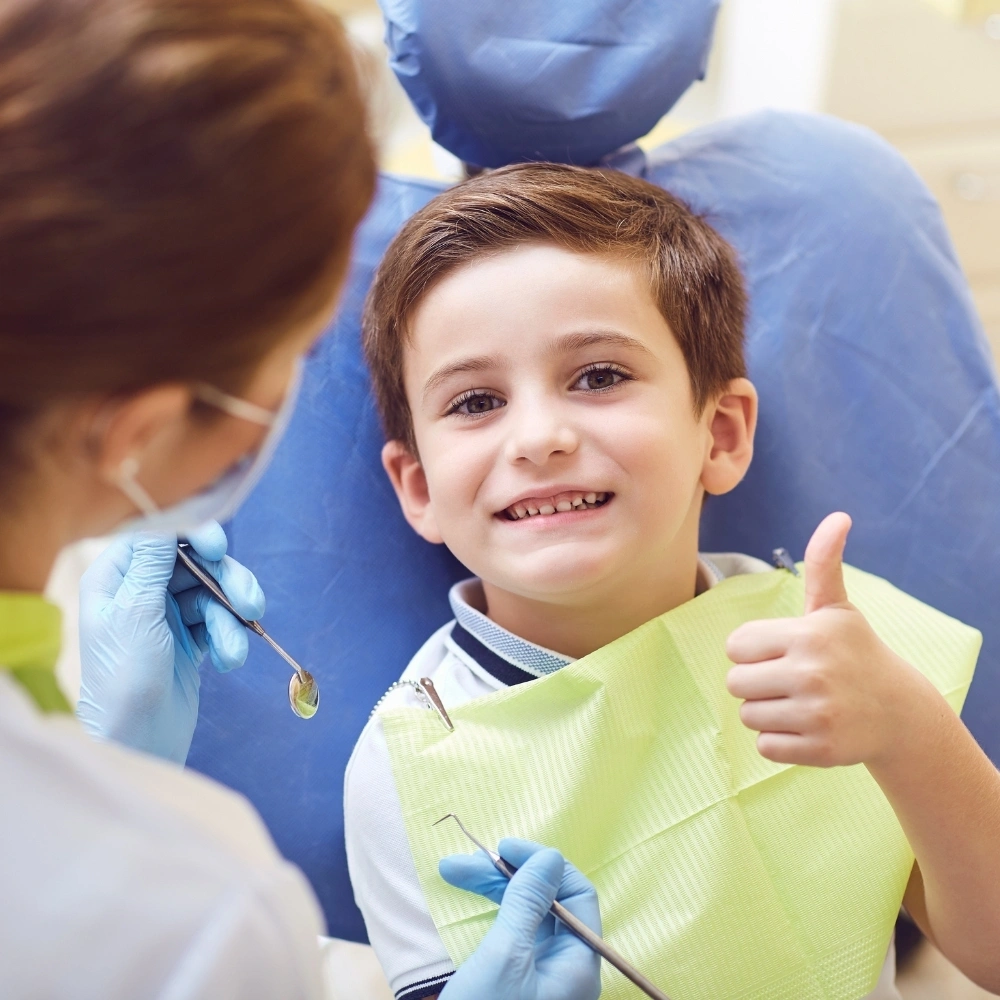 Child giving a thumbs-up during a dental check-up at Dental Art Clinic in Cambridge